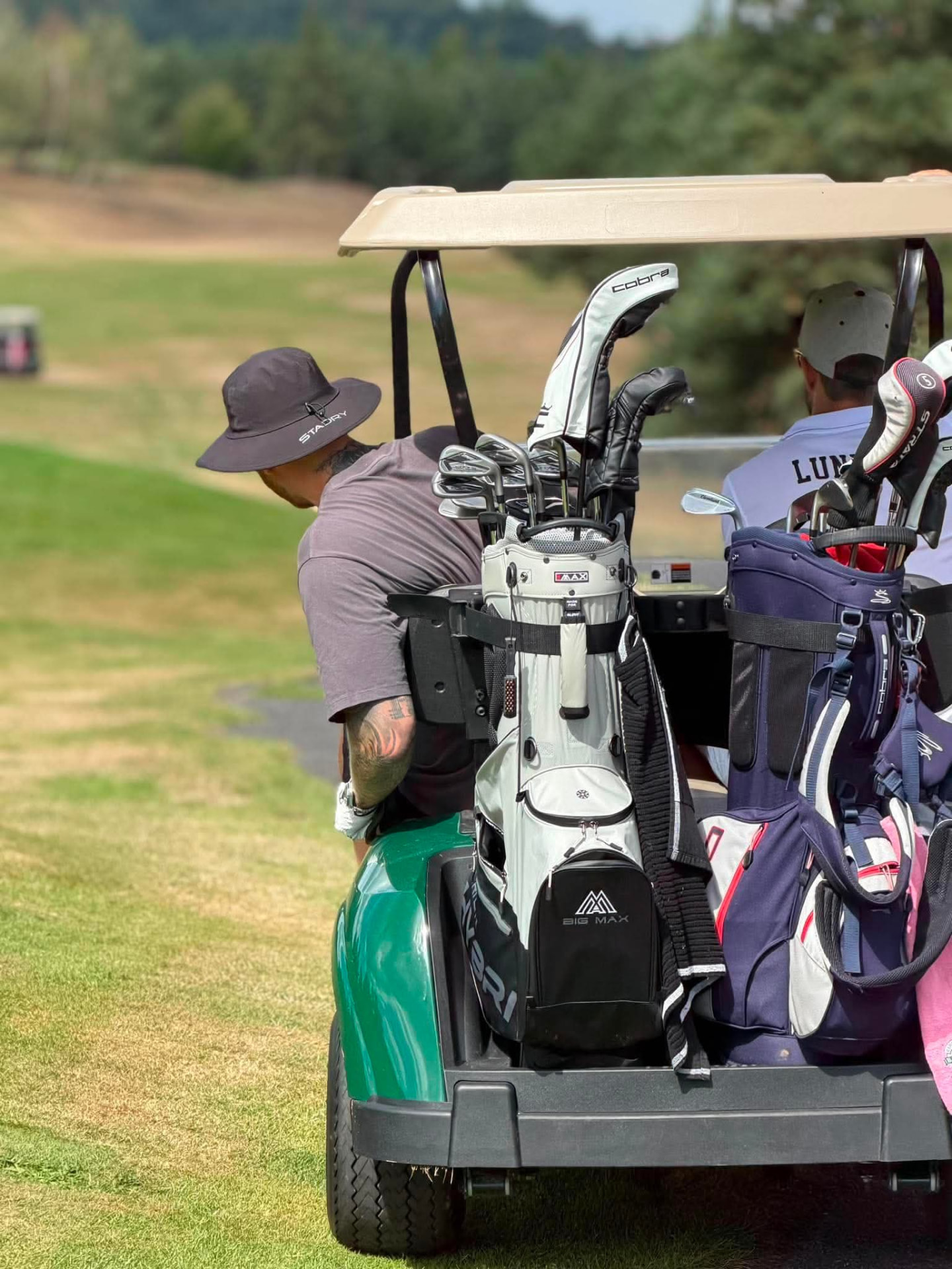 Golf bags loaded on the back of a cart